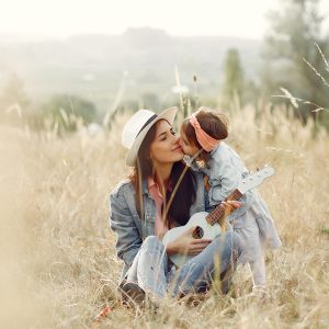 Mother With Little Daughter Playing In A Autumn Field